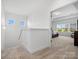 Upstairs hallway leading to a bedroom, with neutral carpet and light-filled windows, offers easy access at 1001 Hampton Grove Rd, Waxhaw, NC 28173
