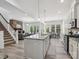 Open-concept living space featuring a kitchen island, stone fireplace, and hardwood flooring, perfect for entertaining at 1001 Hampton Grove Rd, Waxhaw, NC 28173