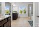 Bright main bathroom featuring a double vanity, large windows, and a glass-enclosed shower at 1001 Hampton Grove Rd, Waxhaw, NC 28173