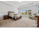 Spacious main bedroom featuring tray ceiling, large windows with neighborhood views, and a seating area at 1001 Hampton Grove Rd, Waxhaw, NC 28173