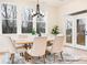 Bright dining room with large windows, modern chandelier, and seating for six, leading to outdoor deck at 1059 Sage Pine Cir, Clover, SC 29710
