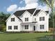 Stunning new construction featuring a classic white exterior, black shutters, and covered front porch at 11009 Tyler Brook Ln # Oak0043, Mint Hill, NC 28227