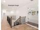 Bright hallway with hardwood floors, staircase with metal balusters and a view into the living area at 11009 Tyler Brook Ln # Oak0043, Mint Hill, NC 28227
