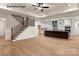An open living room features a staircase and flows into a stylish kitchen with modern appliances at 11009 Tyler Brook Ln # Oak0043, Mint Hill, NC 28227