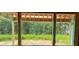 A framed view through unfinished window displays a green, grassy backyard area at 11009 Tyler Brook Ln # Oak0043, Mint Hill, NC 28227