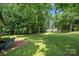 Spacious backyard with mature trees and a brick patio at 1116 S Juniper St, Kannapolis, NC 28081