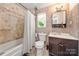 Full bathroom featuring tiled walls, a shower-tub combination, and a dark wood vanity at 1116 S Juniper St, Kannapolis, NC 28081