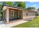 Charming single-story home featuring brick and stone accents, a covered porch, and a well-manicured lawn at 1116 S Juniper St, Kannapolis, NC 28081