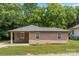 Single-story brick home with stone facade, covered porch, and well-maintained lawn, set against a lush green backdrop at 1116 S Juniper St, Kannapolis, NC 28081