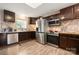 Modern kitchen with stainless steel appliances, dark wood cabinets, tile backsplash, and wood-look floors at 1116 S Juniper St, Kannapolis, NC 28081