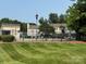 A community swimming pool featuring a well-maintained lawn and shady trees at 1231 Maple Shade Ln, Charlotte, NC 28270