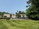A community swimming pool featuring a well-maintained lawn and shady trees at 1231 Maple Shade Ln, Charlotte, NC 28270