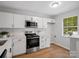 Modern kitchen featuring white cabinets, stainless steel appliances, and a bright window at 1231 Maple Shade Ln, Charlotte, NC 28270