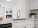 Modern kitchen island with a bar sink open to living room with fireplace at 1231 Maple Shade Ln, Charlotte, NC 28270