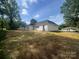 Expansive backyard with lush green grass and white house featuring a covered patio area at 1312 W Monroe Rd, Salisbury, NC 28144