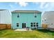 View of a two-story house with green siding, a backyard patio, and a small trampoline at 133 Aspire Cir, Wingate, NC 28174