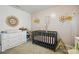 A Bedroom with light pink walls, a crib, a dresser, and floral decorations at 133 Aspire Cir, Wingate, NC 28174