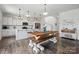 Modern kitchen with white cabinets, stainless steel appliances, a large wooden table with benches and adjacent stairwell at 133 Aspire Cir, Wingate, NC 28174