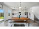 Bright kitchen with white cabinets, stainless steel appliances, a large wooden table and easy access to the stairwell at 133 Aspire Cir, Wingate, NC 28174