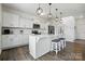 Kitchen island with modern pendant lighting, white cabinets, stainless appliances and breakfast bar seating at 133 Aspire Cir, Wingate, NC 28174