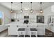 Stylish kitchen island with modern pendant lighting, stainless appliances, white cabinets and breakfast bar seating at 133 Aspire Cir, Wingate, NC 28174