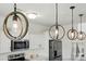 Close-up of modern pendant lights, white cabinets and stainless steel appliances in an open kitchen at 133 Aspire Cir, Wingate, NC 28174
