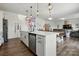 Open kitchen with white cabinets, stainless steel appliances and island with pendant lighting overlooking the Gathering room at 133 Aspire Cir, Wingate, NC 28174