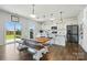Open kitchen with white cabinets, stainless steel appliances, a kitchen island and a wooden table with benches at 133 Aspire Cir, Wingate, NC 28174