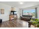 Bright and airy living room with hardwood floors, comfortable seating, and a large television for entertainment at 133 Aspire Cir, Wingate, NC 28174