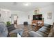 Spacious living room with hardwood floors, plush sofas, and a modern entertainment center with a large TV at 133 Aspire Cir, Wingate, NC 28174