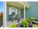 Cozy front porch with seating, attractive landscaping, and a salmon-colored front door at 133 Aspire Cir, Wingate, NC 28174