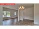Open-concept living room with decorative chandelier, and an entry door at 1369 Secrest Commons Dr, Monroe, NC 28112