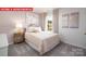 Bright bedroom featuring a decorative comforter, stylish lamps, and large sun-filled window at 1373 Zermatt Ct, Monroe, NC 28112