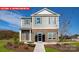 Charming two-story home featuring stone accents, gray siding, manicured lawn, and inviting front entrance at 1373 Zermatt Ct, Monroe, NC 28112