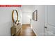 Inviting foyer featuring beautiful wood floors, console table with decor, mirror, and natural light at 1373 Zermatt Ct, Monroe, NC 28112