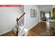 Bright hallway featuring wood floors, stairs with carpet and railing, with views into the dining and living area at 1373 Zermatt Ct, Monroe, NC 28112