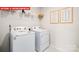 Functional laundry room featuring modern white appliances, overhead shelving, and framed decor at 1373 Zermatt Ct, Monroe, NC 28112