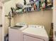 Well-organized laundry room with washer, dryer, and shelving stocked with supplies at 13820 Cypress Woods Dr, Huntersville, NC 28078