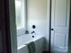 A modern bathroom featuring a bathtub with a window and marble tile at 1802 Cooper Ave, Kannapolis, NC 28081