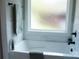 A modern bathroom featuring a bathtub with a window and marble tile at 1802 Cooper Ave, Kannapolis, NC 28081