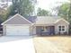 Charming home with stone and gray siding, complemented by a driveway and a two-car garage at 1802 Cooper Ave, Kannapolis, NC 28081