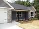 View of the home's facade showcases stone detailing, fresh landscaping, and an attached garage at 1802 Cooper Ave, Kannapolis, NC 28081