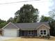 Charming single-story home featuring stone accents, a modern garage door, and beautiful landscaping at 1802 Cooper Ave, Kannapolis, NC 28081