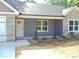 Close-up of the front of a gray single-story home with a gray door and a stone facade at 1802 Cooper Ave, Kannapolis, NC 28081