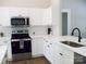 Bright modern kitchen featuring white cabinets, white marble countertops, and stainless steel appliances at 1802 Cooper Ave, Kannapolis, NC 28081
