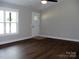 Bright living room featuring wood flooring, a white door, and a window providing natural light at 1802 Cooper Ave, Kannapolis, NC 28081