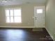 Bright living room with hardwood floors, a window, and a white door at 1802 Cooper Ave, Kannapolis, NC 28081