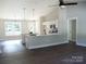 Open-concept space with white cabinets, stainless steel appliances, island with marble countertop, and modern lighting at 1802 Cooper Ave, Kannapolis, NC 28081
