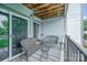 View of the cozy balcony featuring wood decking, furniture, and sliding glass doors to the interior at 18741 Nautical Dr # 205, Cornelius, NC 28031