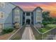 Inviting condo exterior with dusk sky, bridge entrance, and well-maintained landscaping at 18741 Nautical Dr # 205, Cornelius, NC 28031